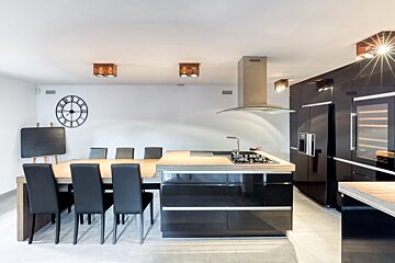 A kitchen with black cabinets and a clock on the wall