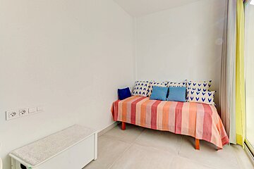 A bed with a striped blanket and blue and white pillows