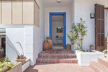 A blue door is open to a room with a painting on the wall
