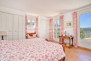 A bedroom with a bed and a window that says made in janssens provence
