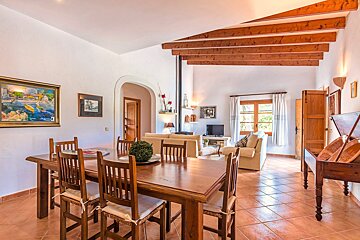 A living room with a table and chairs and a painting on the wall
