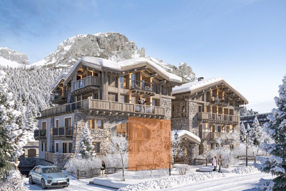 Snowy mountain resort with luxury stone-and-wood chalets, people, a car, and a highlighted orange section on one building.