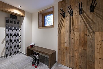 A pair of ski boots are sitting on a wooden bench