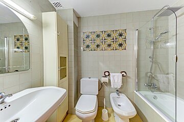 A bathroom with a toilet a sink and a bidet