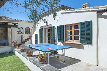 A donic ping pong table sits outside of a house