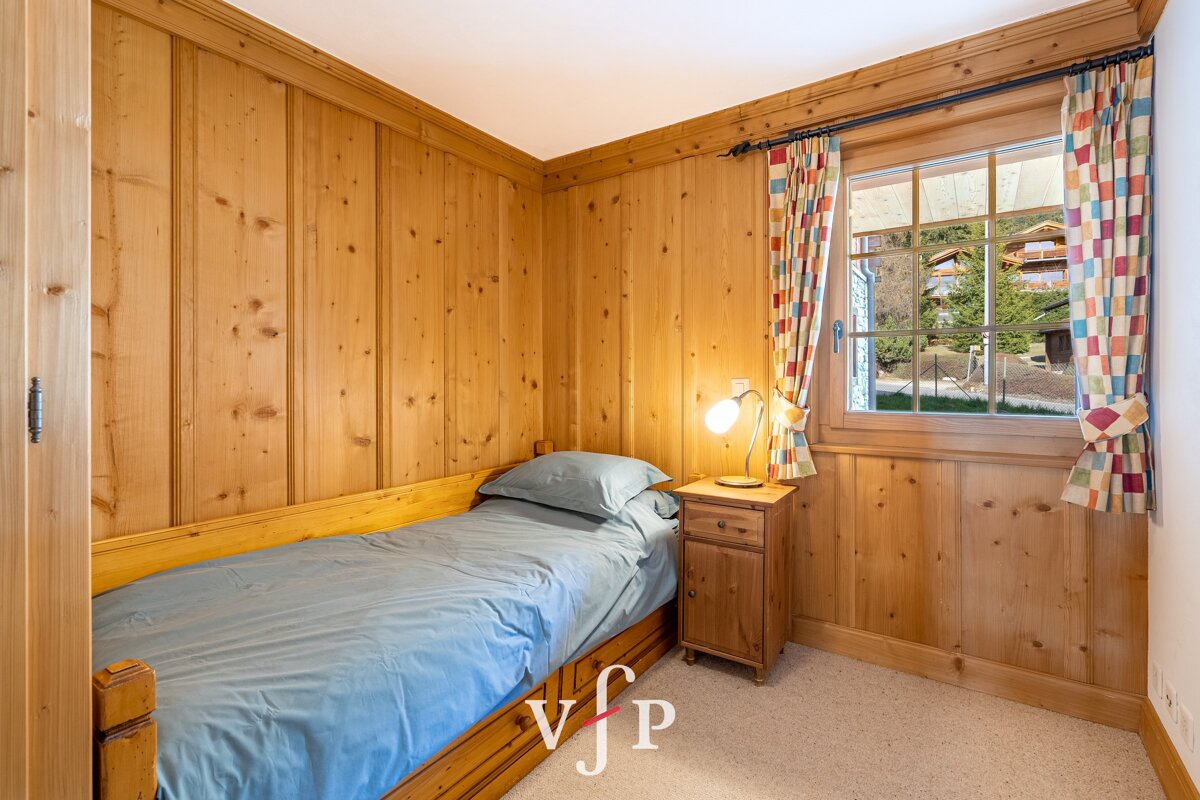 A bedroom with a single bed and a nightstand with the letters vjp on the bottom