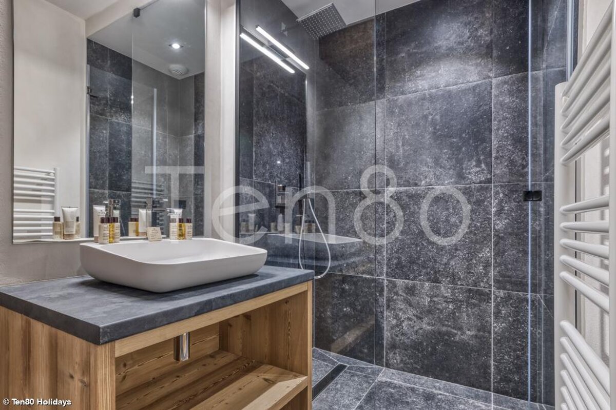 A bathroom with a sink and a shower with the word tengo on the wall