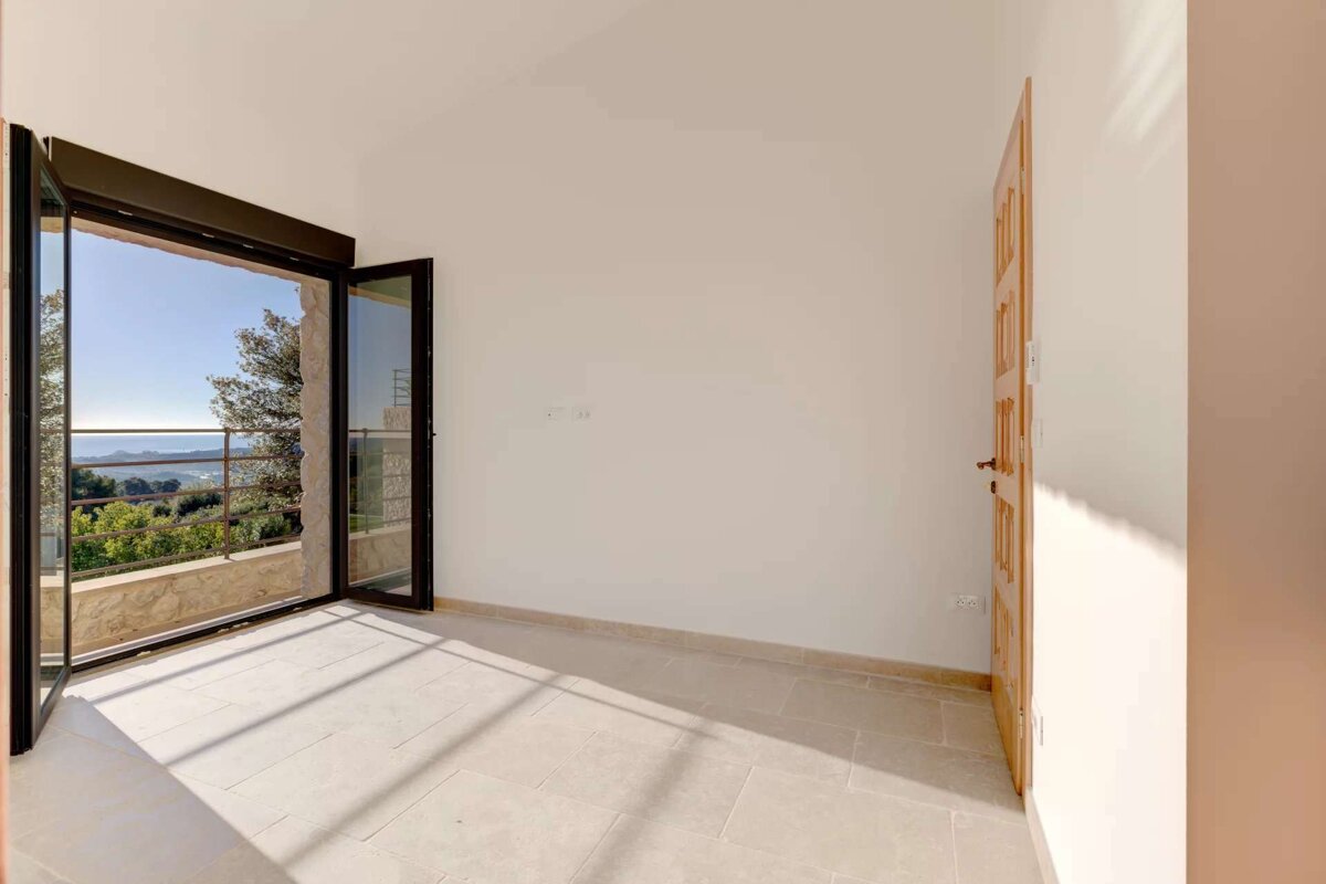 An empty room with a balcony and a door