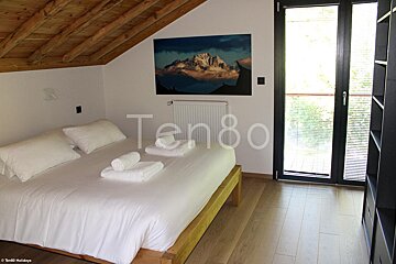 A bedroom with a bed and a picture on the wall that says ten80