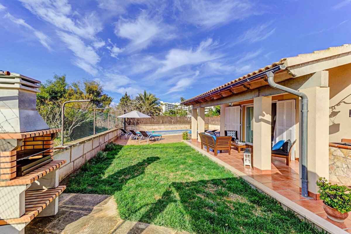 The backyard of a house with a bbq and a swimming pool