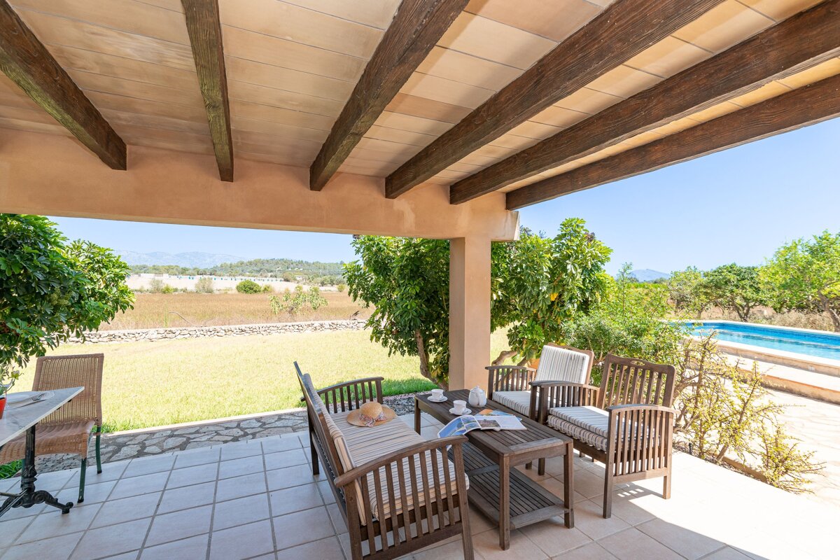 A patio with a couch and chairs and a table with a magazine on it