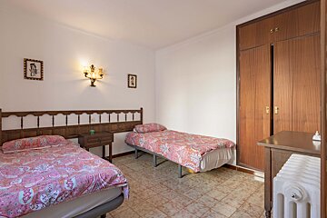 A bedroom with two beds and a radiator