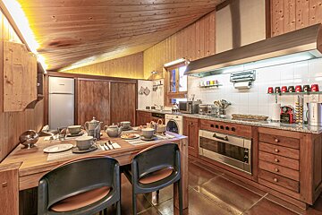 A bedroom with a bed a chair and a lamp