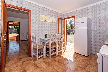 A kitchen with a table and chairs and a refrigerator