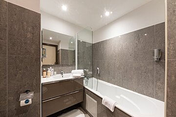 A bathroom with a bathtub a sink and a mirror