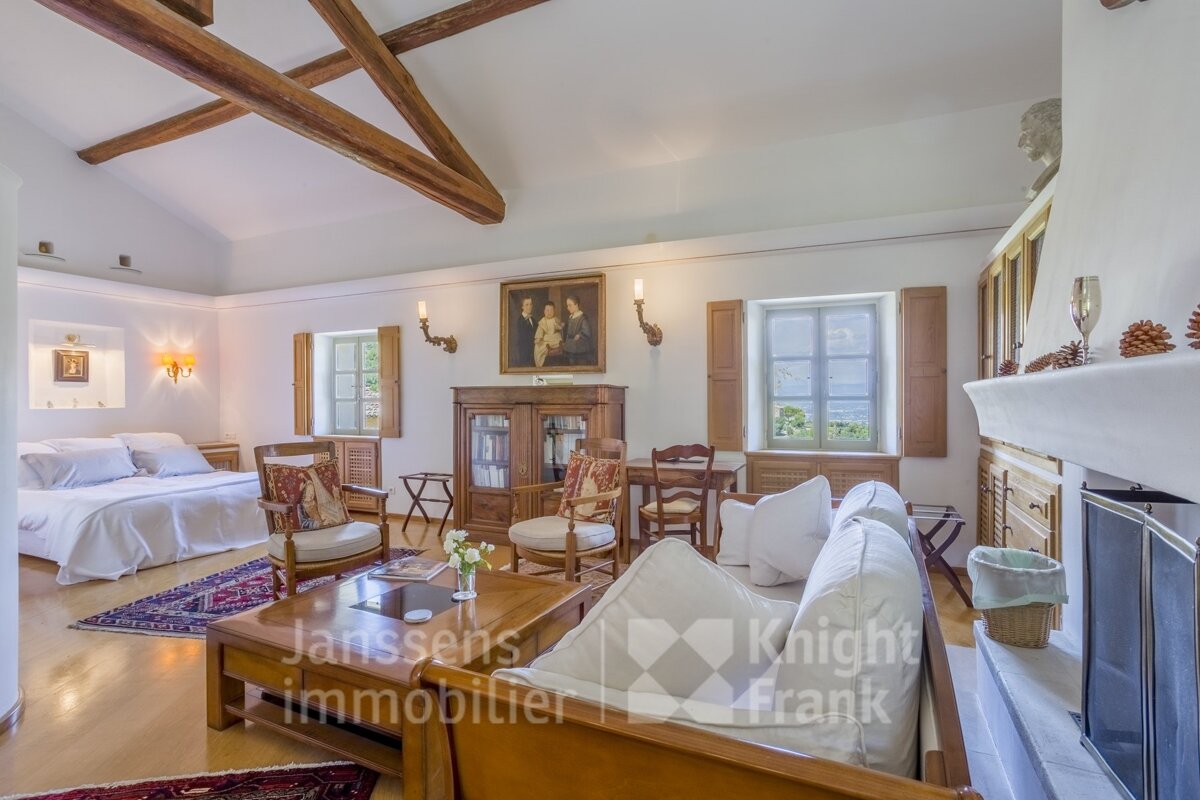 A living room with a couch and a fireplace and a sign that says janssens immobilier