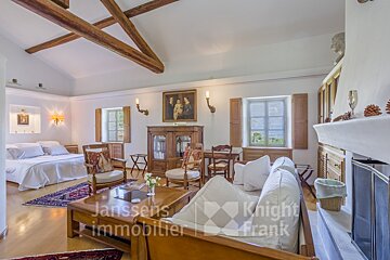A living room with a couch and a fireplace and a sign that says janssens immobilier