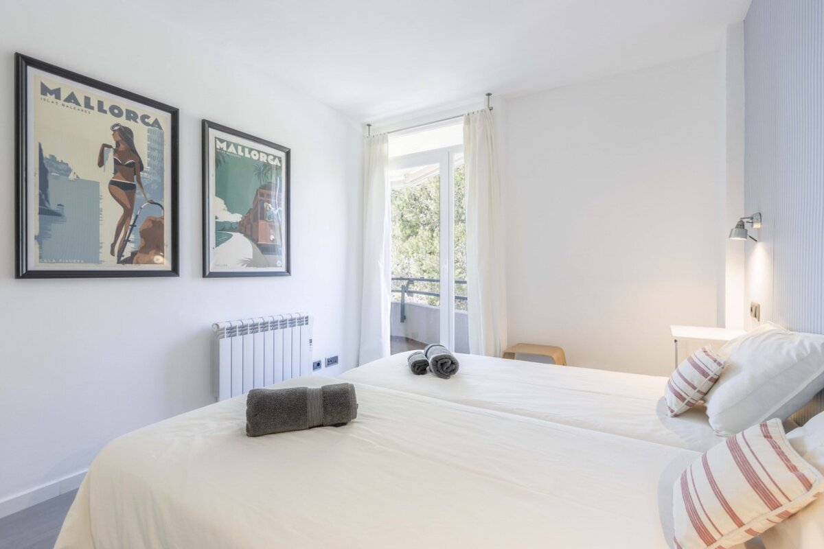 Two framed mallorca posters hang above a bed