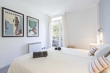 Two framed mallorca posters hang above a bed