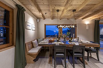 A dining room with a wooden table and chairs