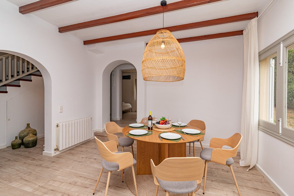 A dining room table with a bottle of wine on it