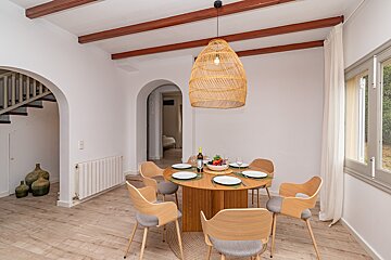 A dining room table with a bottle of wine on it