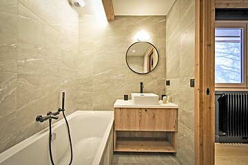 A bathroom with a bathtub sink and mirror