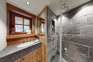 A bathroom with a sink and a walk in shower