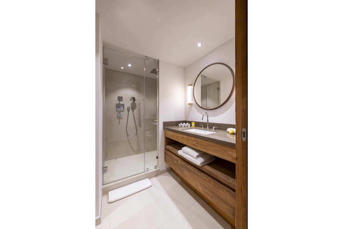 A bathroom with a walk in shower and a sink