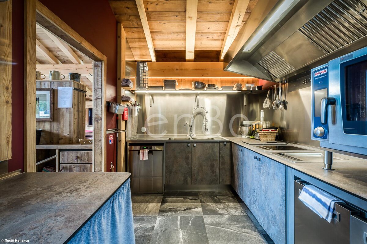 A kitchen with a stainless steel appliance and the word emc on the wall