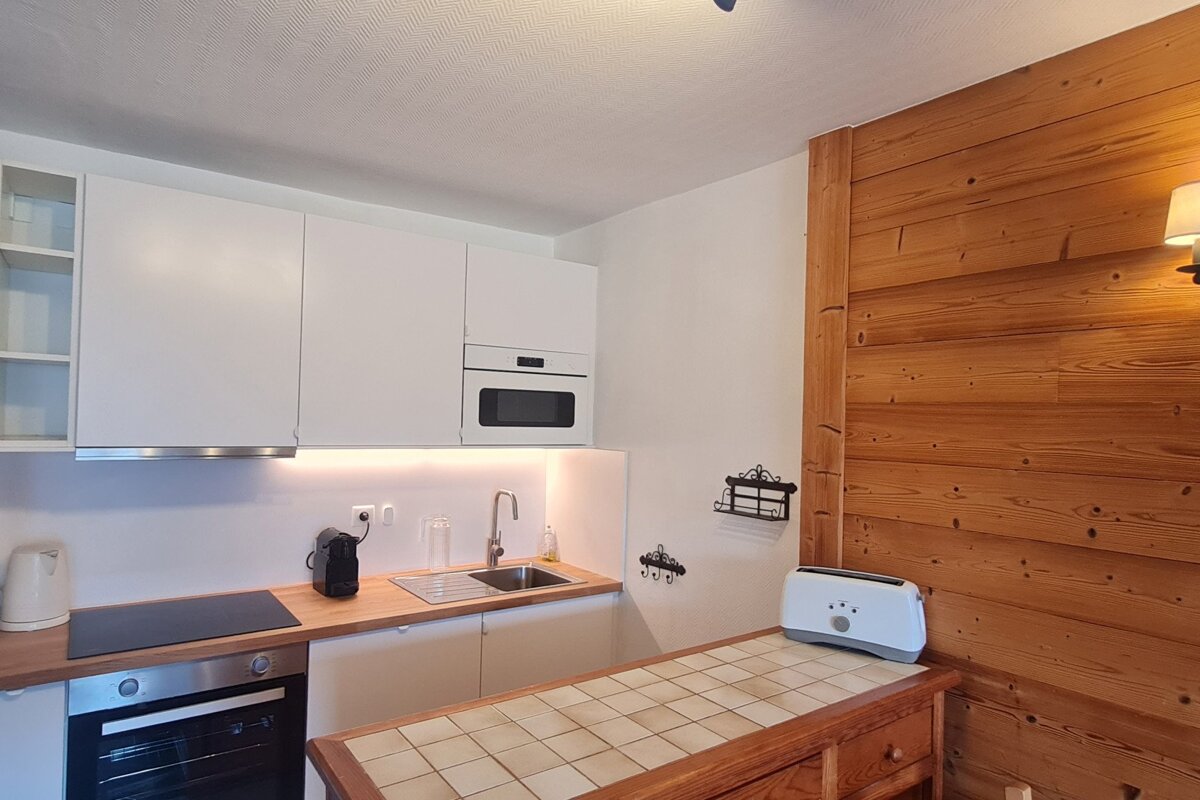 A kitchen with white cabinets and a toaster on the counter
