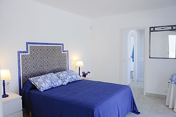 A bedroom with a blue bed and a blue headboard