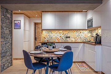 A kitchen with a table and chairs and a picture on the wall that says hotel