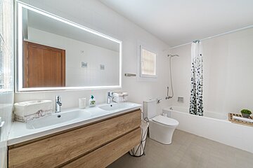 A bathroom with two sinks a toilet and a bathtub
