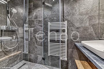 A bathroom with a towel rack and the word tengo on the wall