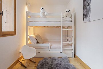 A bunk bed with two teddy bears on top of it