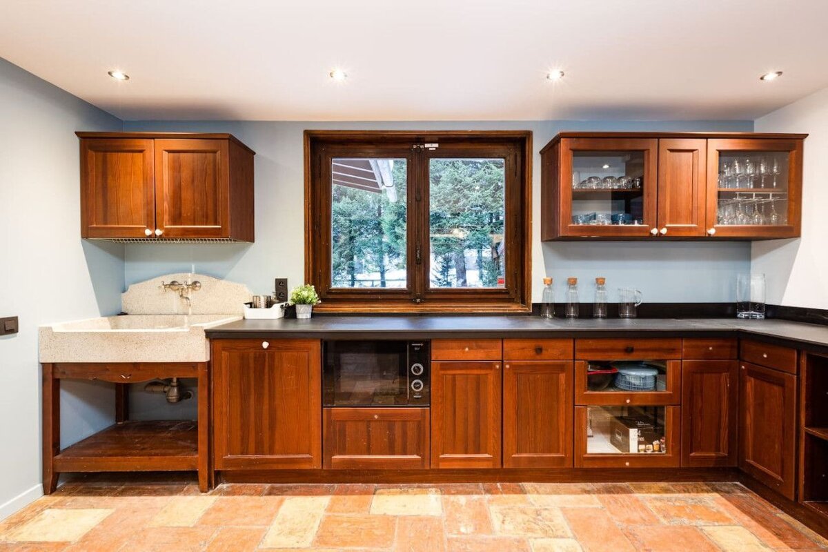 A kitchen with wooden cabinets and a window