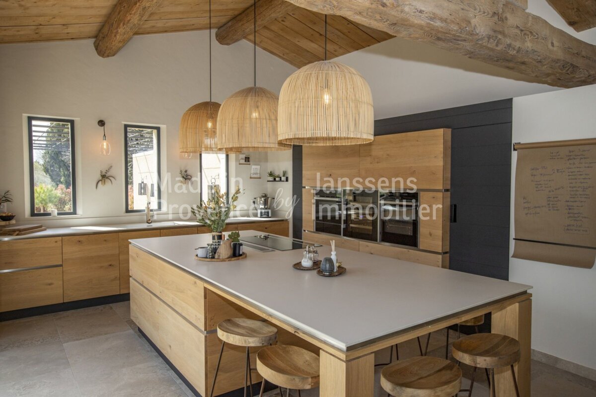 A kitchen with a large island and a sign that says janssens immobilier