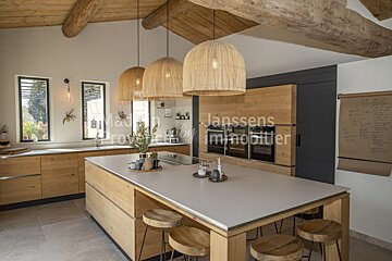 A kitchen with a large island and a sign that says janssens immobilier