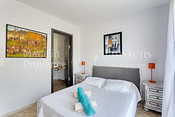 A bedroom with a bed and a picture on the wall that says made in provence