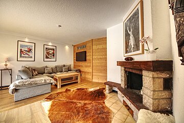 A living room with a couch and a fireplace with a poster on the wall that says