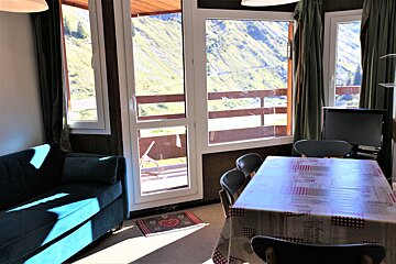 A room with a table and chairs and a table cloth that says