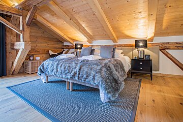 A bedroom with a king size bed and a rug