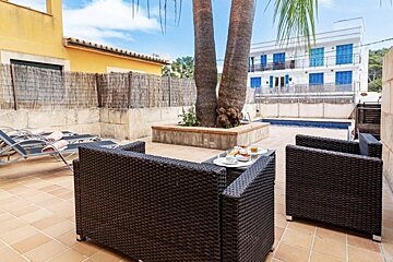 A patio with chairs and a table with plates of food on it