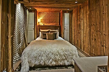 A bedroom with a bed with a fur blanket on it