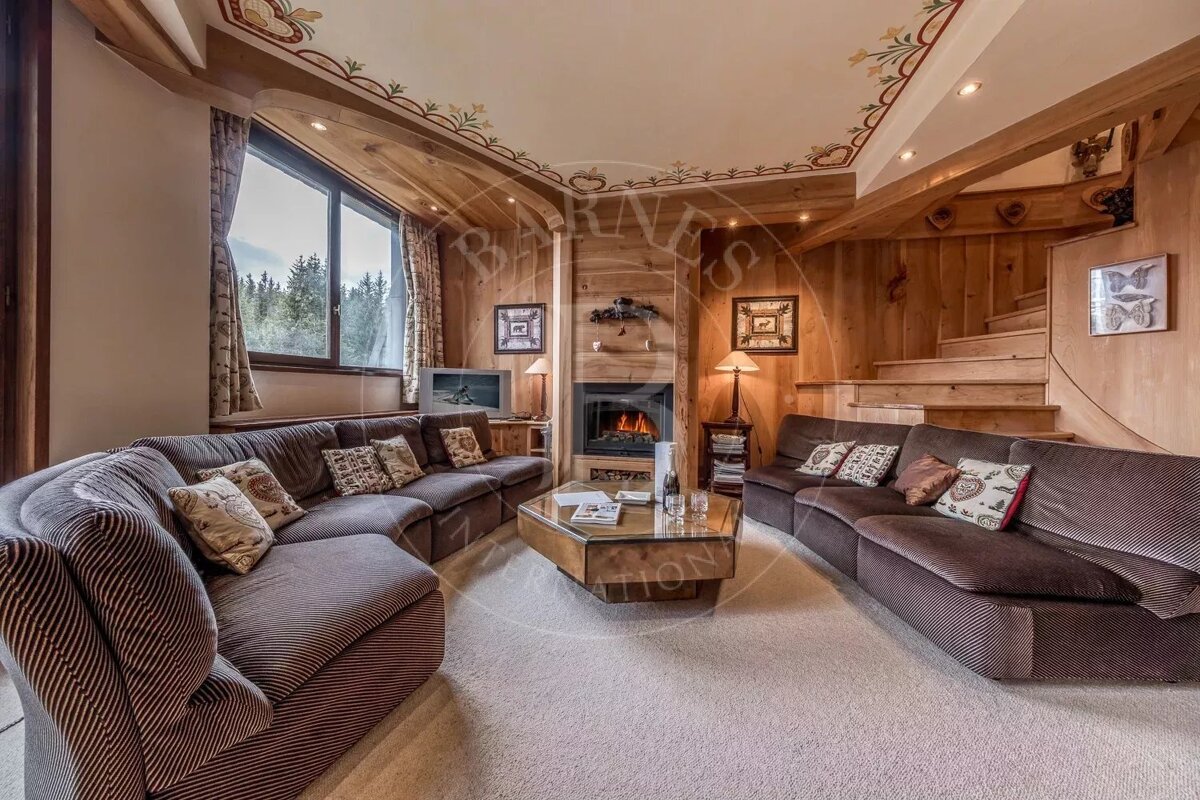 A living room with a couch and a fireplace with the word barnes on the ceiling