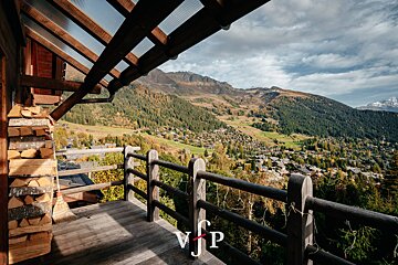 A balcony with a view of a mountain valley with the letters vjp on it