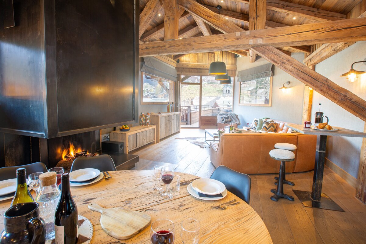 A wooden table with a bottle of wine on it