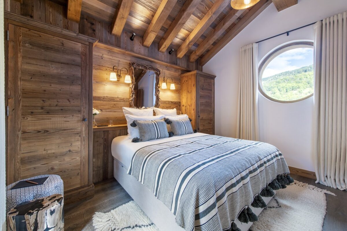A bedroom with a bed and a round window