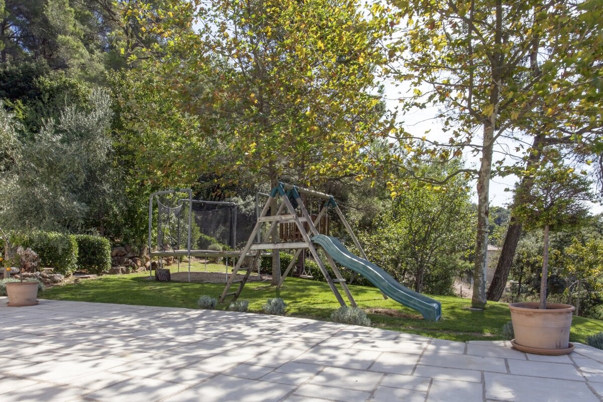 A playground with a slide and swings in the backyard